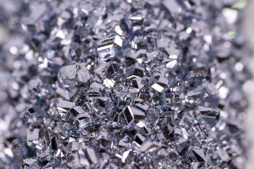 Osmium besitzt eine kristalline Oberfläche, deren Kristalle unter dem Mikroskop grau und bläulich funkeln